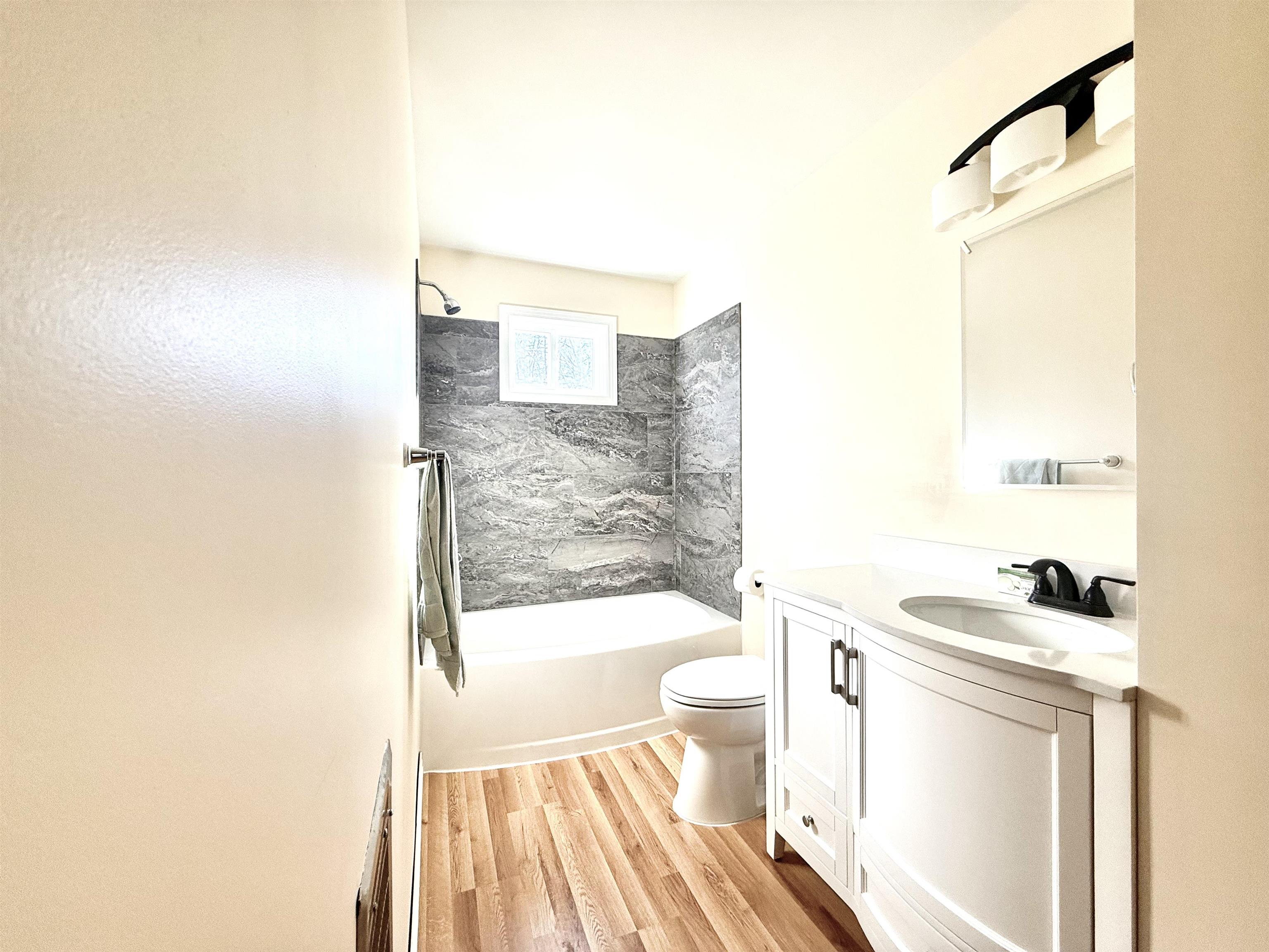 Full bathroom featuring vanity, bathing tub / shower combination, and light wood-type flooring