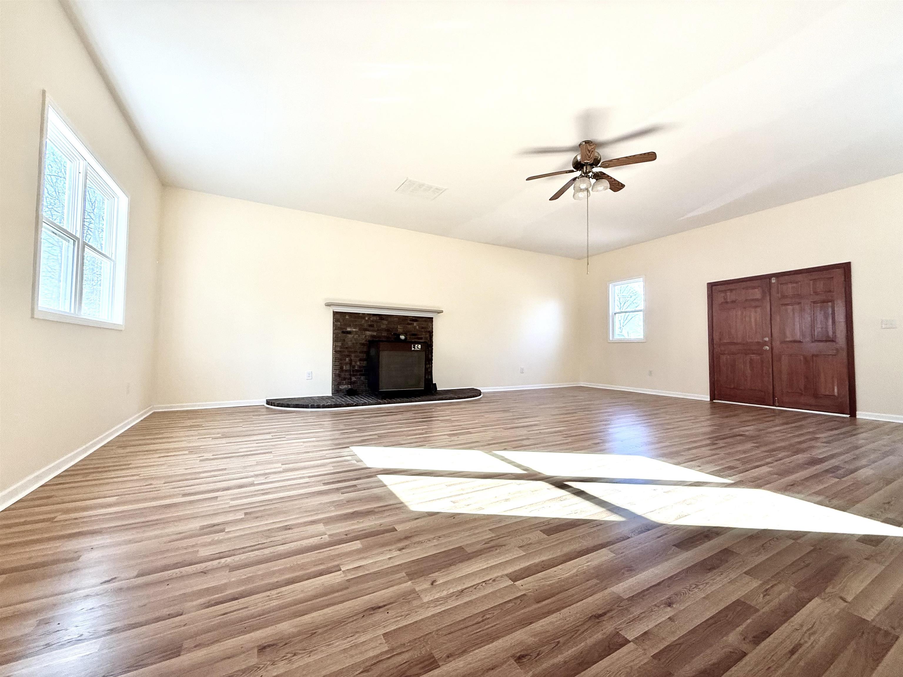 120 Rhodes Drive Middleton, TN 38052 - Photo 4 of 16 a view of empty room with wooden floor and fan