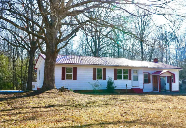 a view of house with yard and tree in front of it