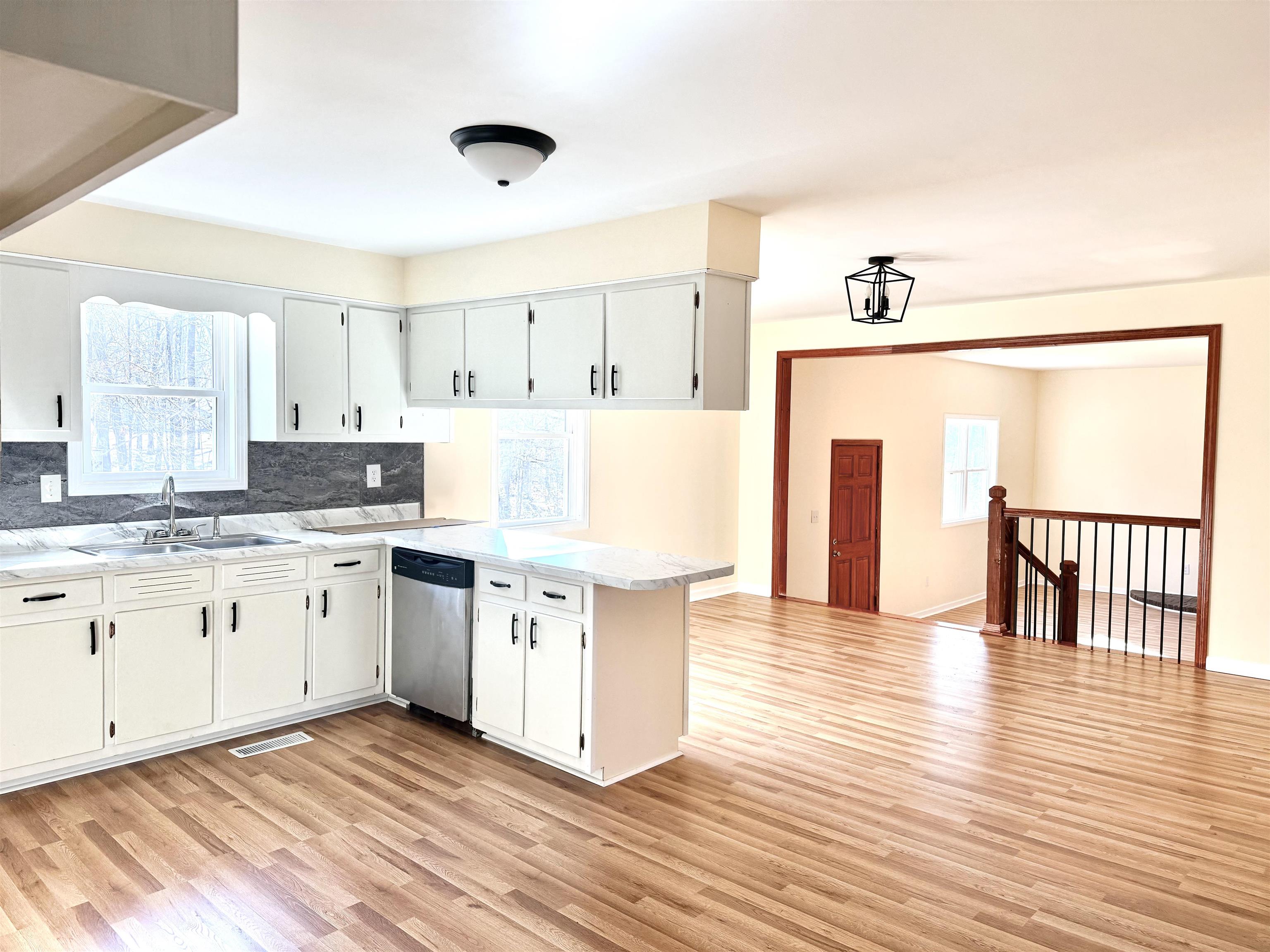 120 Rhodes Drive Middleton, TN 38052 - Photo 7 of 16 a large kitchen with granite countertop a stove top oven a sink and white cabinets with wooden floor