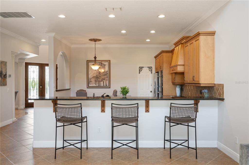 8119 Vía Rosa Orlando, FL 32836 - Photo 14 of 62 a kitchen with stainless steel appliances kitchen island granite countertop a stove a refrigerator and white cabinets with wooden floor