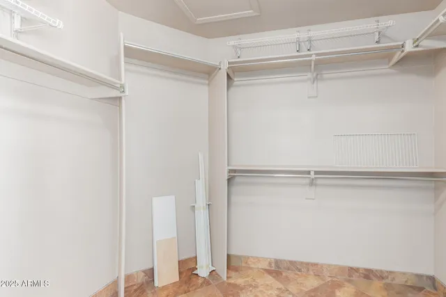 a view of walk in closet with empty racks