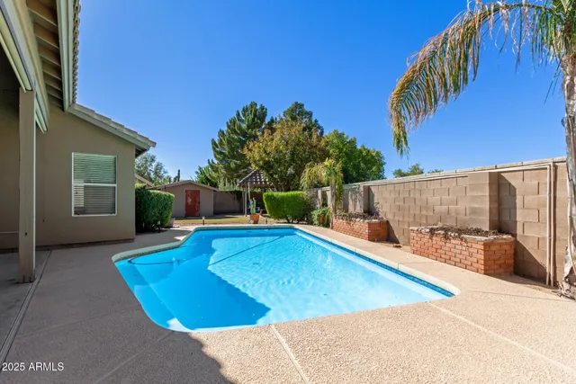 a view of a house with swimming pool and sitting area