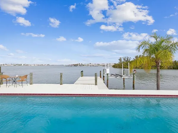 a view of a house with pool and chairs