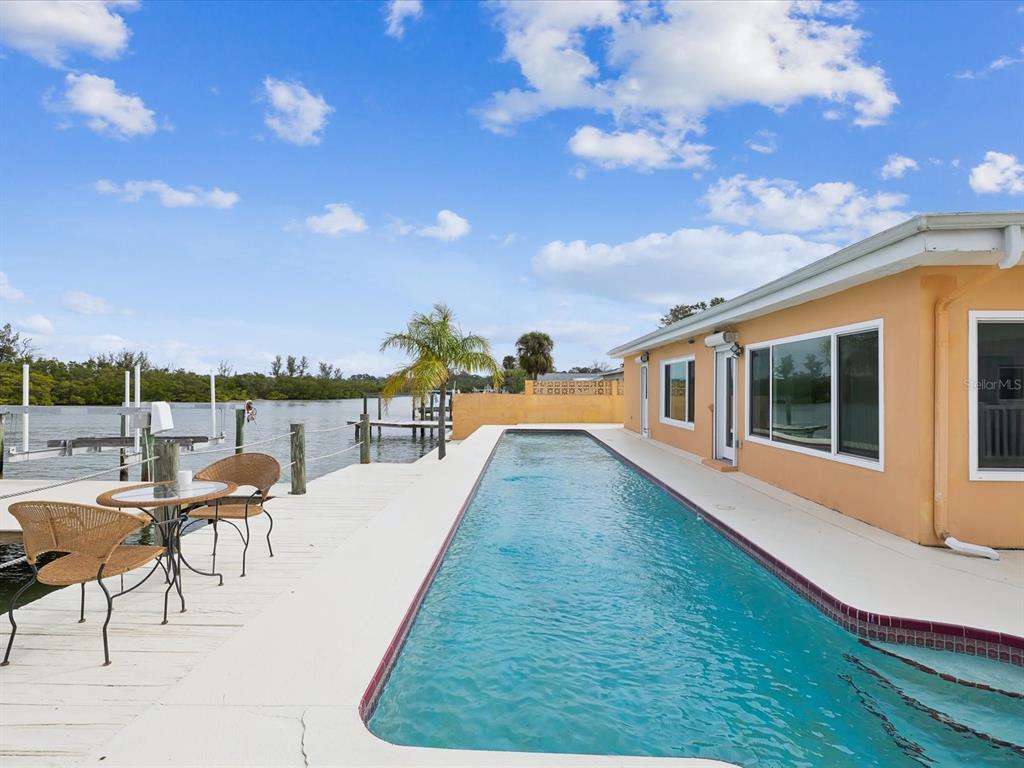 11549 48th Avenue North St. Petersburg, FL 33708 - Photo 21 of 37 a view of a house with pool and chairs