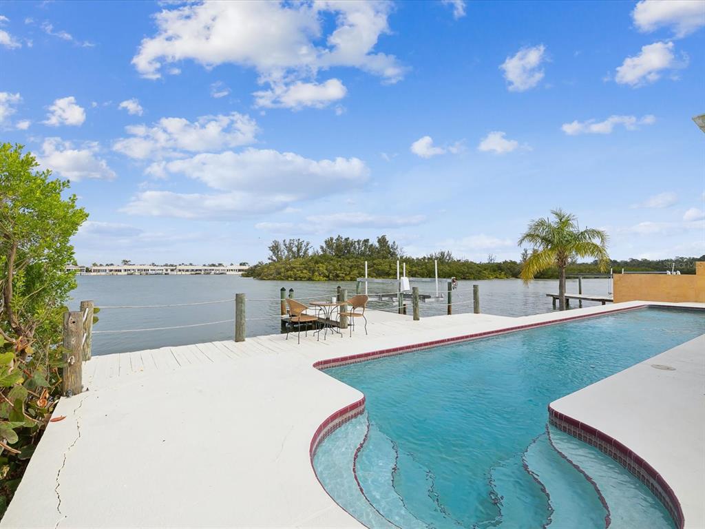 11549 48th Avenue North St. Petersburg, FL 33708 - Photo 33 of 37 a swimming pool with outdoor seating and yard in back