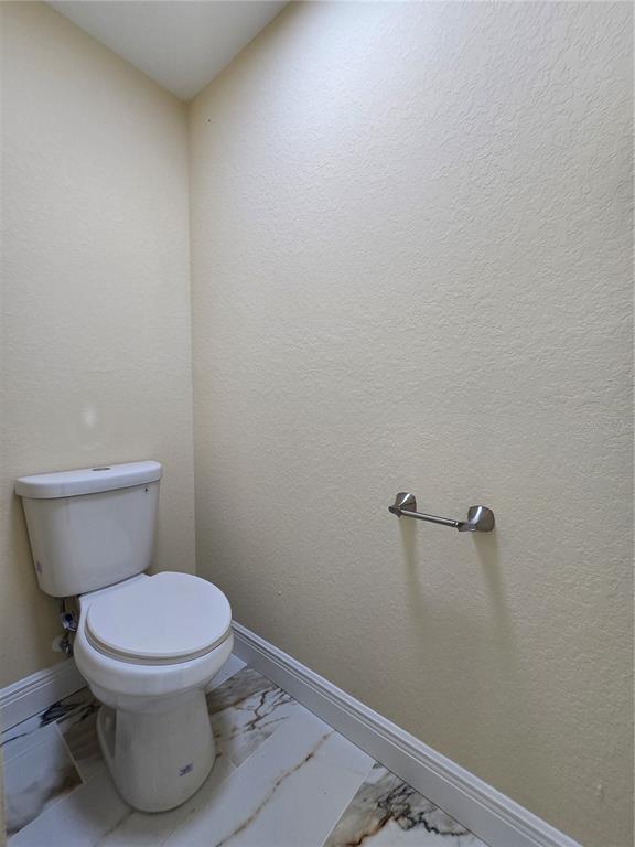 9 Locust Run Track Ocala, FL 34472 - Photo 16 of 38 a white toilet sitting next to a wooden cabinet