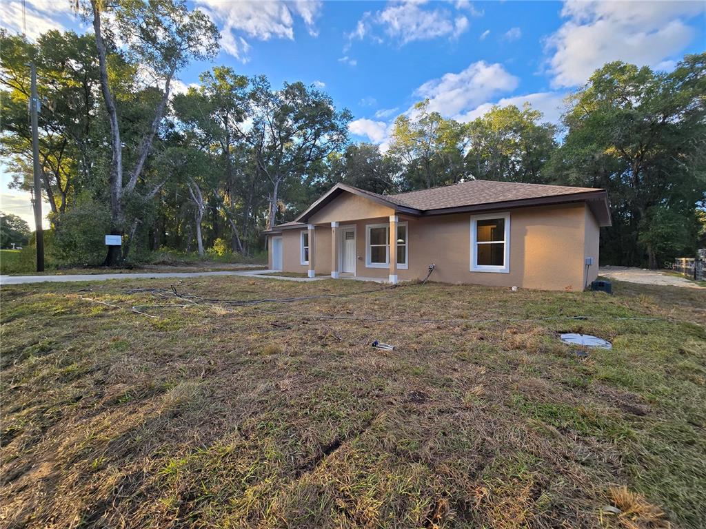 9 Locust Run Track Ocala, FL 34472 - Photo 2 of 38 a backyard of a house with plants and large tree