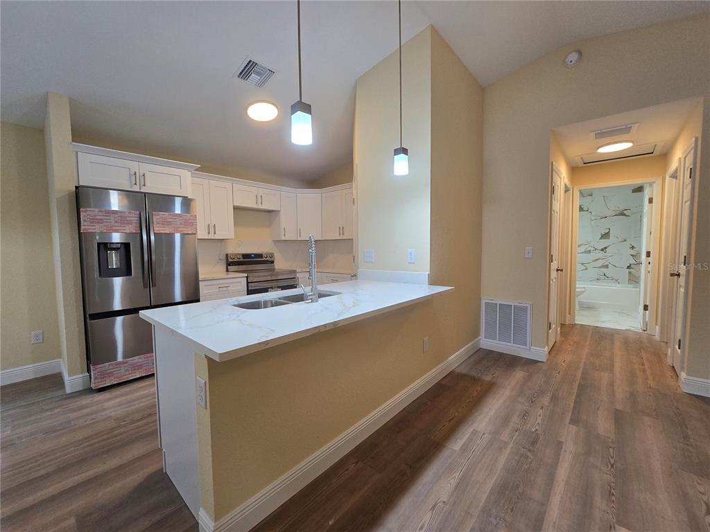 9 Locust Run Track Ocala, FL 34472 - Photo 28 of 38 a large kitchen with stainless steel appliances a large counter top a stove a refrigerator and a sink