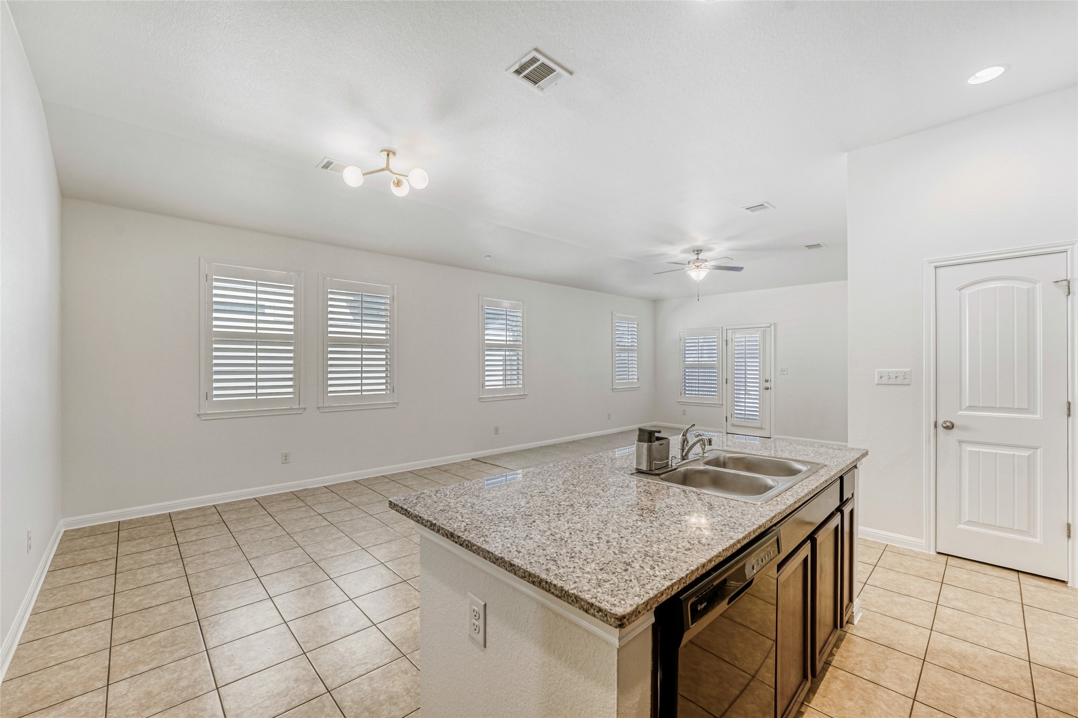 410 Anacua Loop, Unit 30 Manchaca, TX 78652 - Photo 14 of 33 Kitchen with light tile patterned floors, black dishwasher, a center island with sink, and a ceiling fan