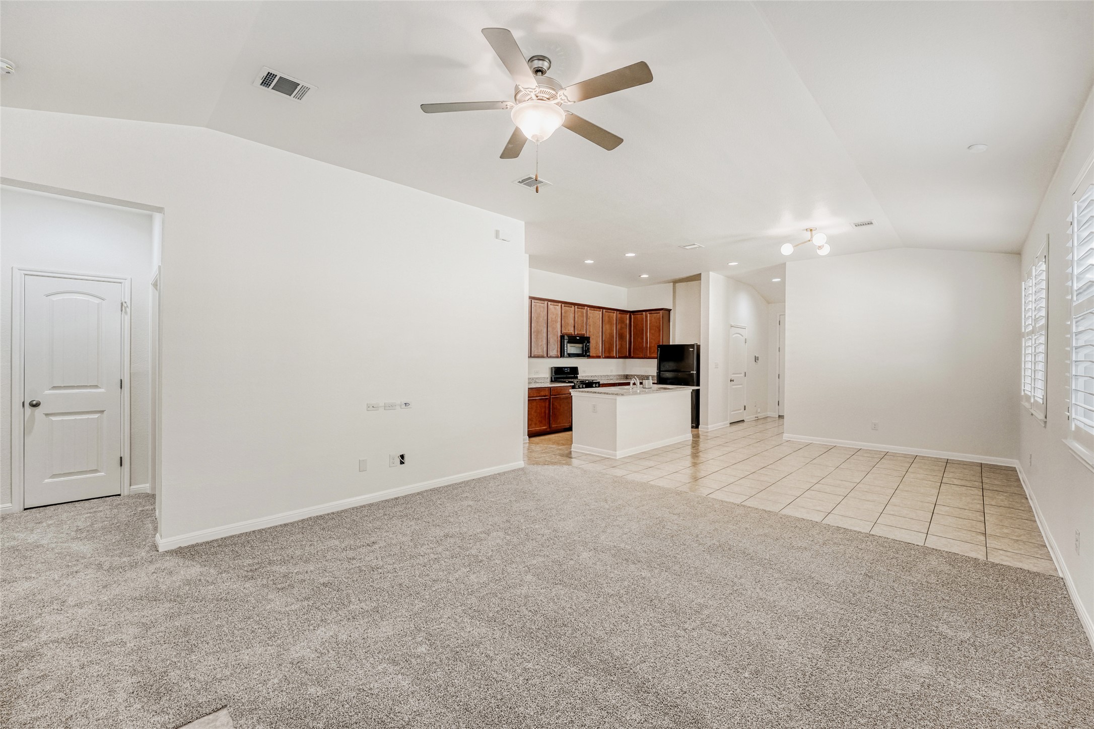 410 Anacua Loop, Unit 30 Manchaca, TX 78652 - Photo 15 of 33 Unfurnished living room featuring light colored carpet, a ceiling fan, light tile patterned floors, and recessed lighting