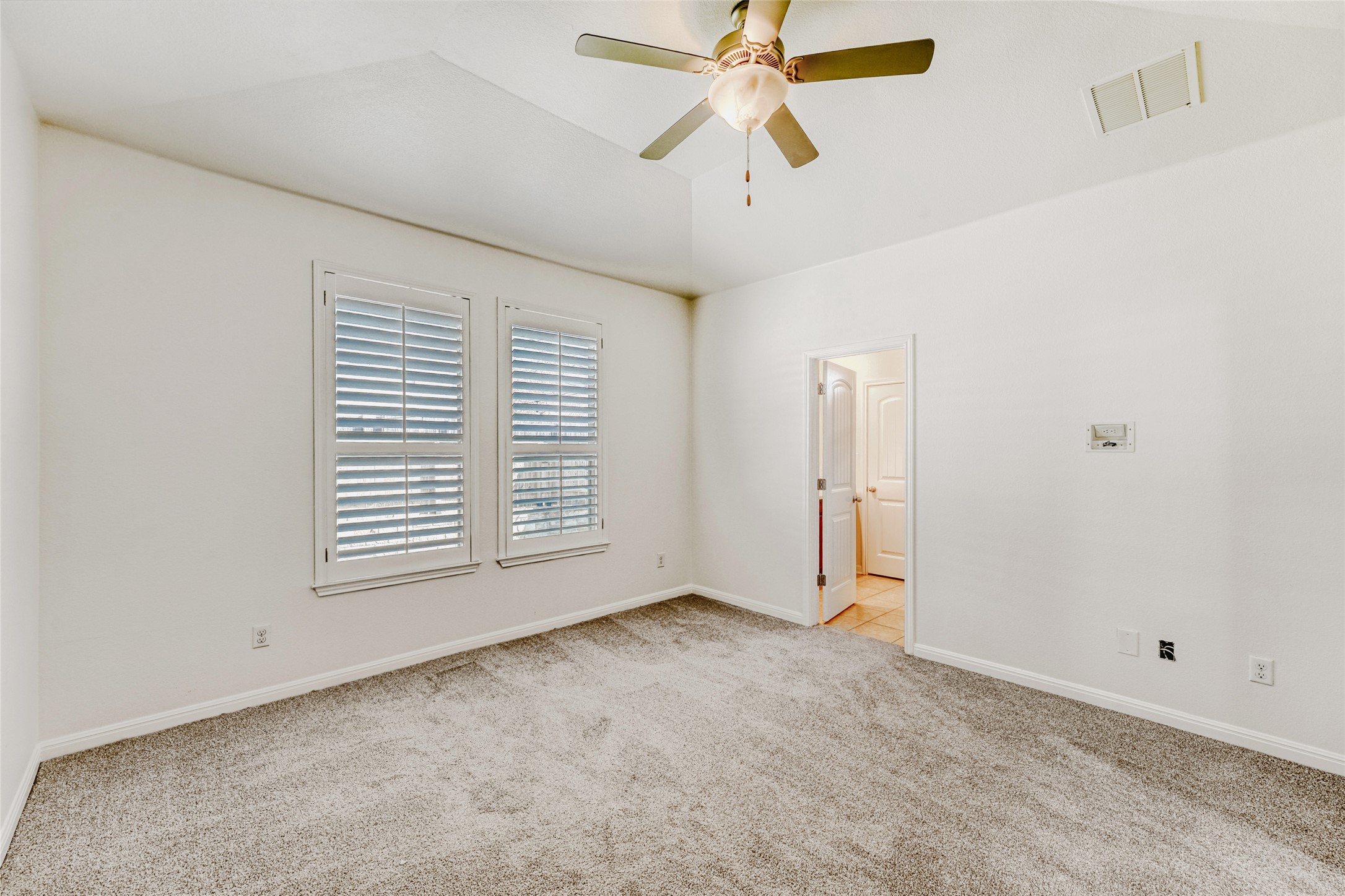 410 Anacua Loop, Unit 30 Manchaca, TX 78652 - Photo 19 of 33 Primary bedroom featuring light colored carpet, ceiling fan, and lofted ceiling