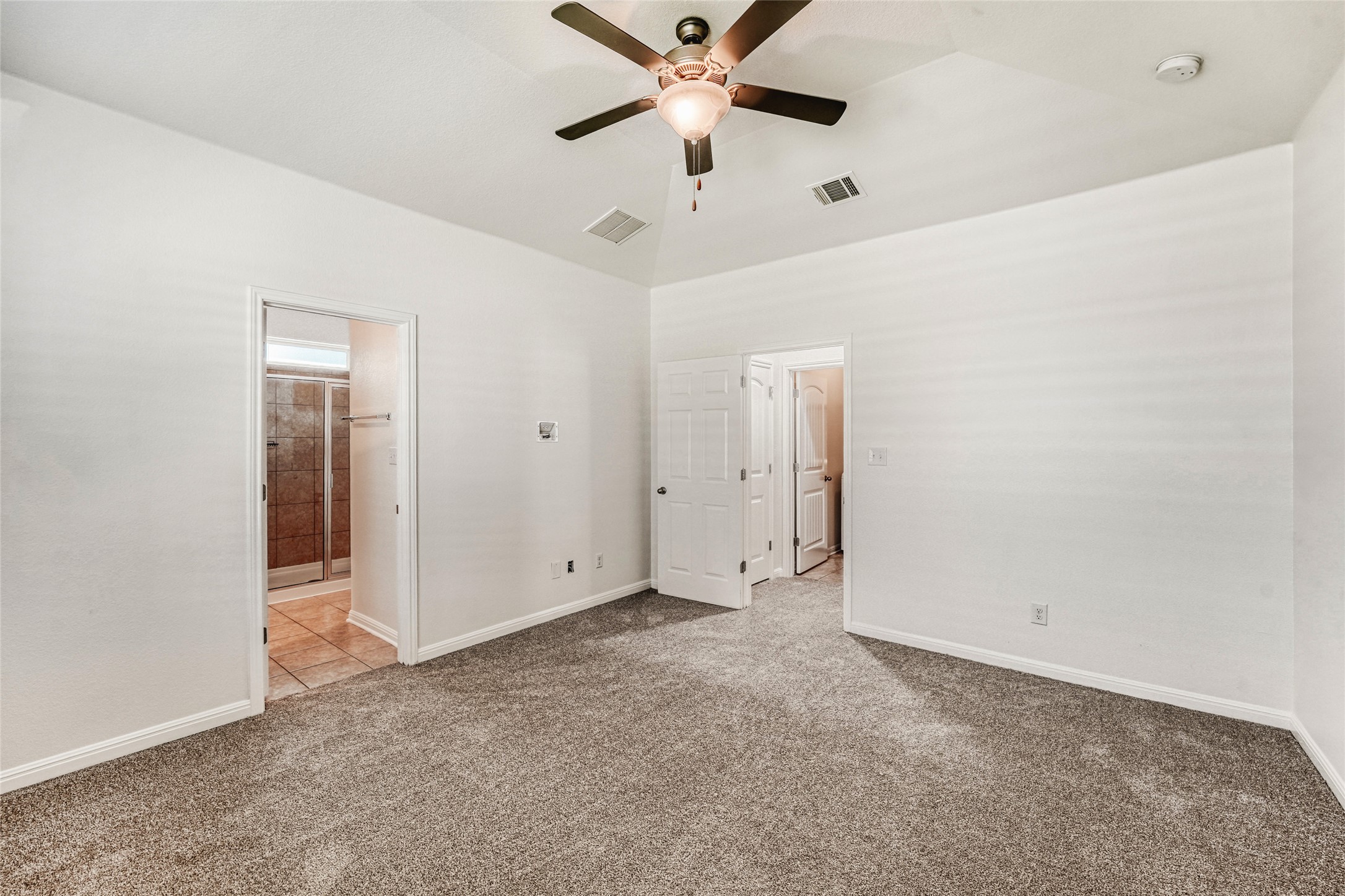410 Anacua Loop, Unit 30 Manchaca, TX 78652 - Photo 20 of 33 Primary bedroom with carpet floors, a ceiling fan, ensuite bathroom, and lofted ceiling