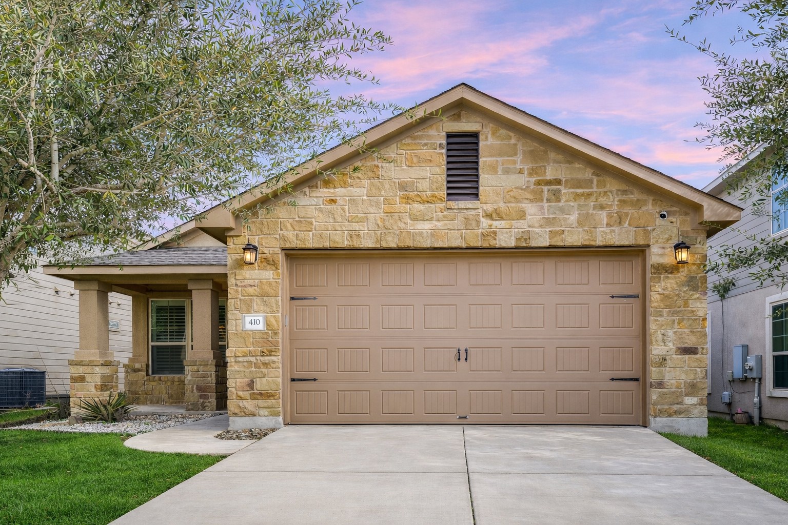 410 Anacua Loop, Unit 30 Manchaca, TX 78652 - Photo 8 of 33 View of front facade featuring stone, concrete driveway, and an attached garage