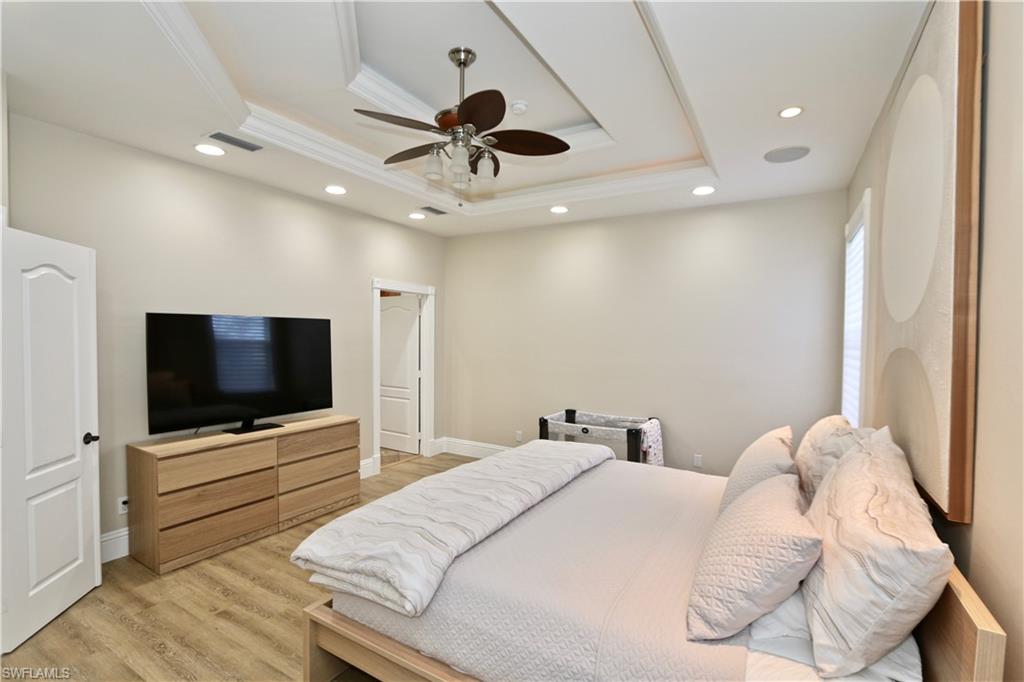 2855 Coach House Way Naples, FL 34105 - Photo 28 of 42 Bedroom with recessed lighting, a ceiling fan, light wood-style floors, ornamental molding, and a raised ceiling