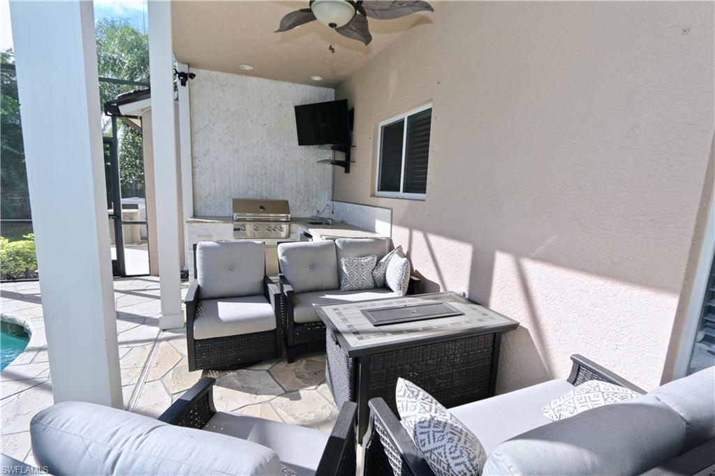 2855 Coach House Way Naples, FL 34105 - Photo 32 of 42 View of patio / terrace with an outdoor kitchen and area to lounge, ceiling fan, and an outdoor pool