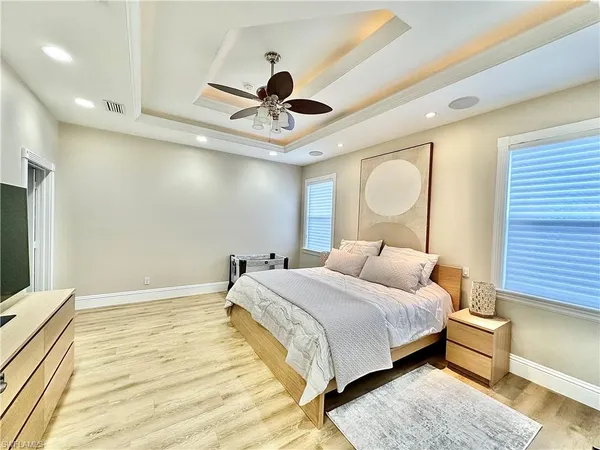 a bedroom with a large bed rug and wooden floor