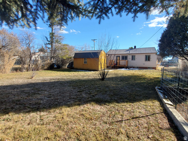 722 Adams Street Montpelier, ID 83254 - Photo 21 of 22 Back of property featuring a lawn, a metal roof, and a shed