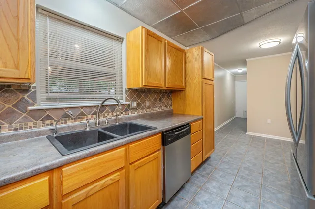 a kitchen with stainless steel appliances granite countertop a sink and a refrigerator