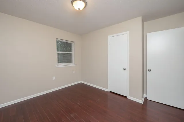a view of a room with wooden floor and white walls