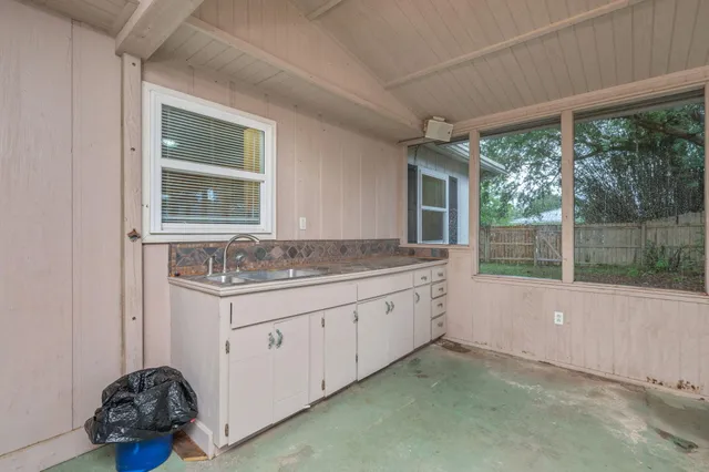 a bathroom with a granite countertop sink and a window