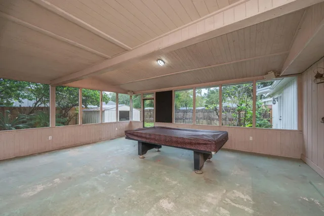 a room with pool table and wooden floor