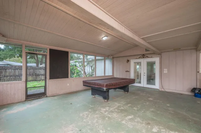 a room with pool table and windows