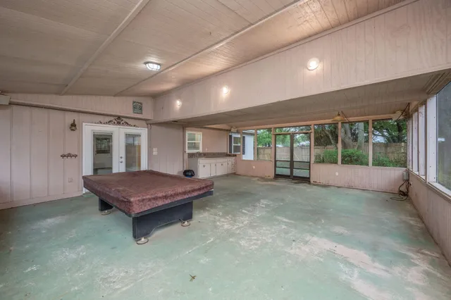 a spacious bedroom with a bed and wooden floor