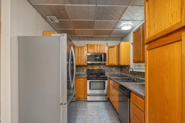 a kitchen with stainless steel appliances a refrigerator and a stove
