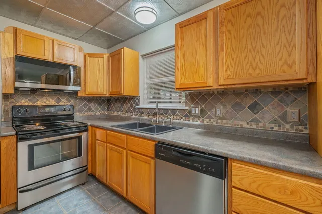 a kitchen with stainless steel appliances granite countertop a sink a stove and cabinets