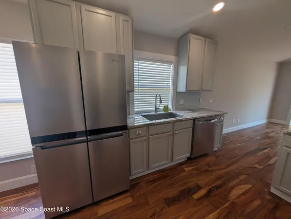 a kitchen with stainless steel appliances granite countertop a refrigerator sink and cabinets