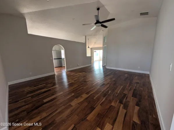 a view of empty room with wooden floor