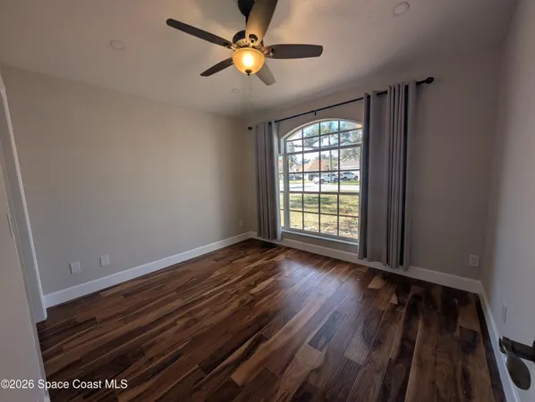wooden floor in an empty room with a window