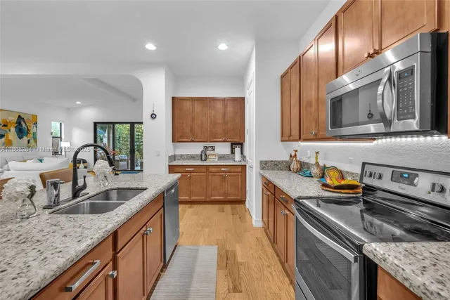 a kitchen with stainless steel appliances granite countertop a sink stove and refrigerator