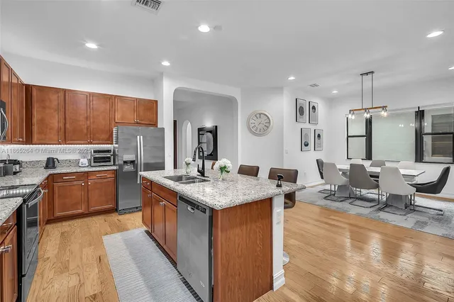 a kitchen with stainless steel appliances granite countertop a sink stove and refrigerator