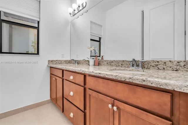 a bathroom with a granite countertop sink and a mirror