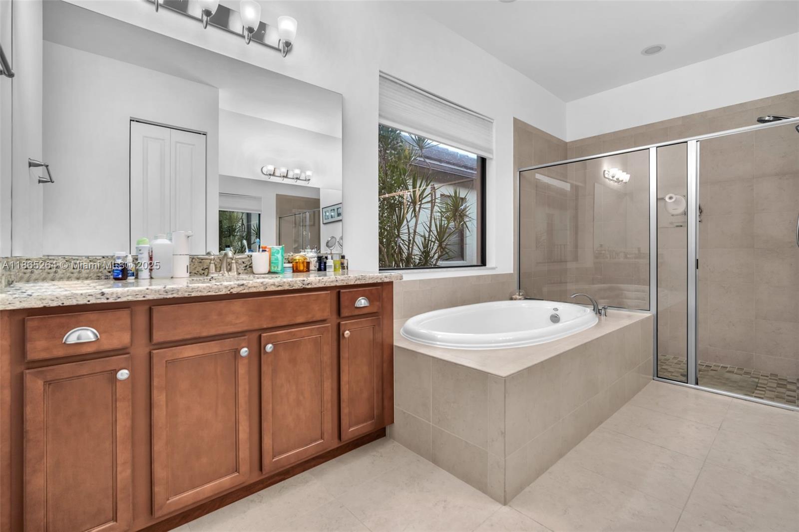 1281 Southwest 113th Way, Unit 1281 Pembroke Pines, FL 33025 - Photo 21 of 38 a bathroom with a sink double vanity mirror and a bathtub