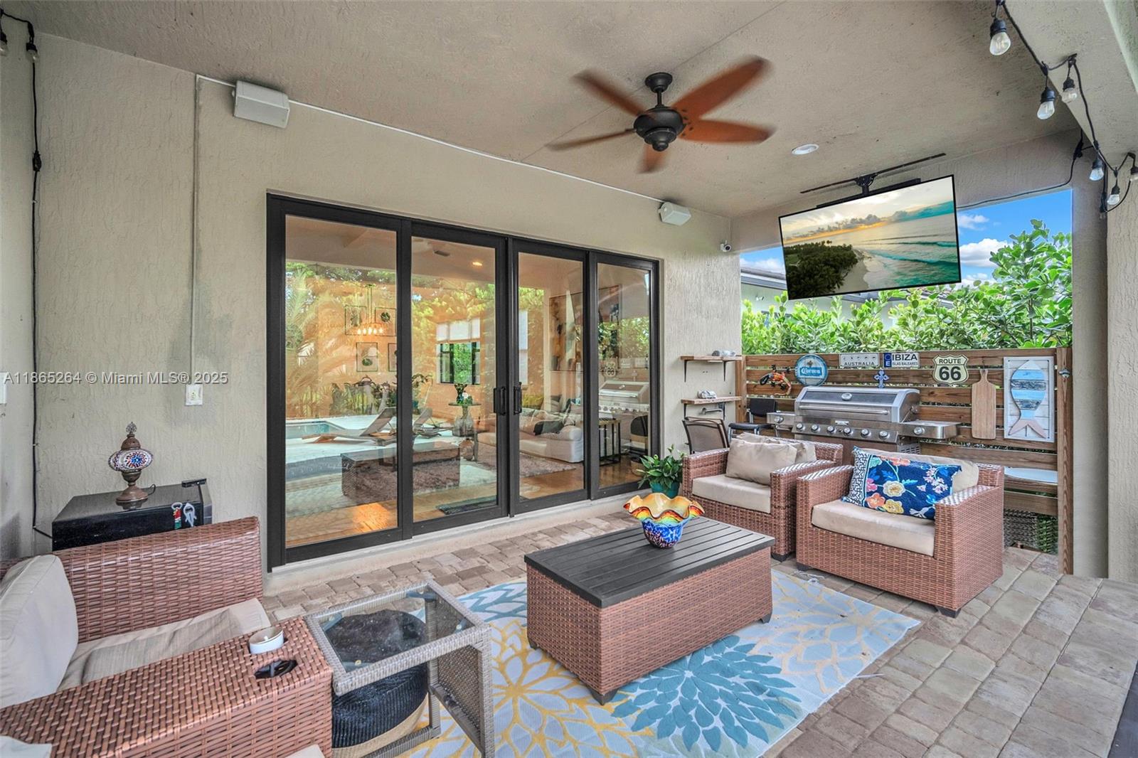 1281 Southwest 113th Way, Unit 1281 Pembroke Pines, FL 33025 - Photo 26 of 38 a living room with patio furniture and a flat screen tv