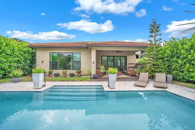 a view of a house with swimming pool and sitting area