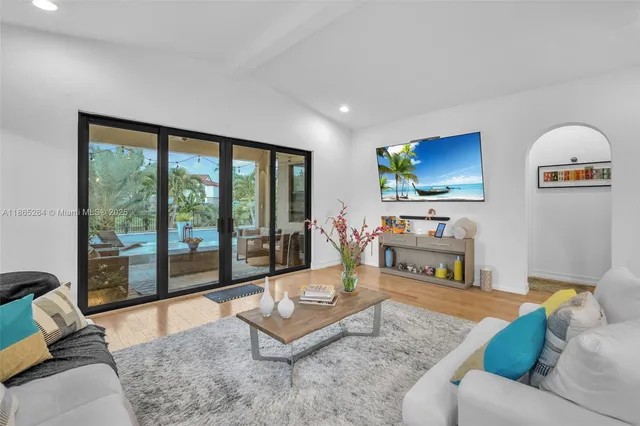 a living room with furniture a flat screen tv and a large window