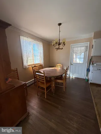 a dining room with furniture a chandelier and wooden floor