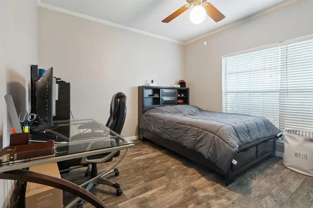 a bedroom with a bed wooden floor and a flat screen tv