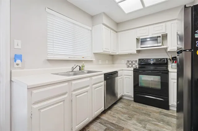 a kitchen with granite countertop white cabinets and white appliances