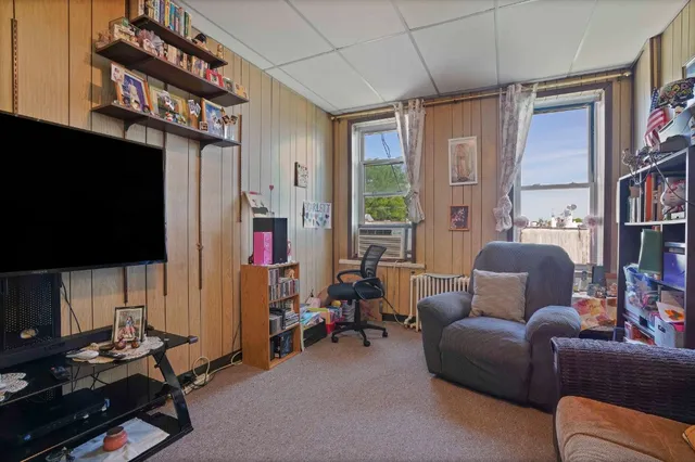 a bedroom with a bed a flat screen tv and dresser