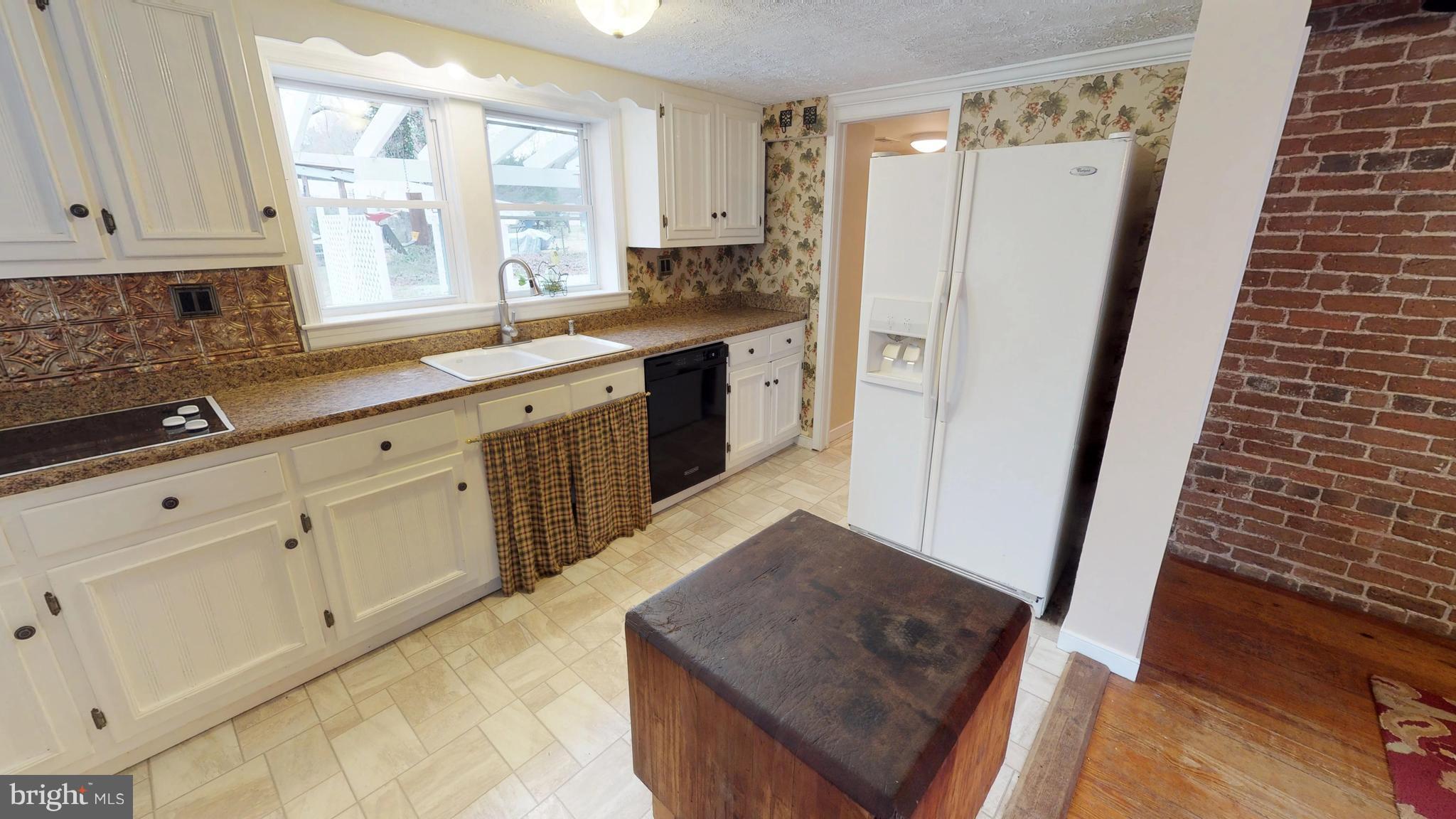527 Hawkins Farm Road Bumpass, VA 23024 - Photo 20 of 30 a kitchen with white cabinets and window