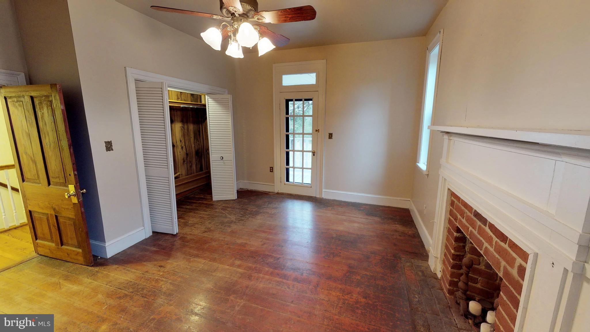 527 Hawkins Farm Road Bumpass, VA 23024 - Photo 23 of 30 wooden floor in an empty room with a fireplace