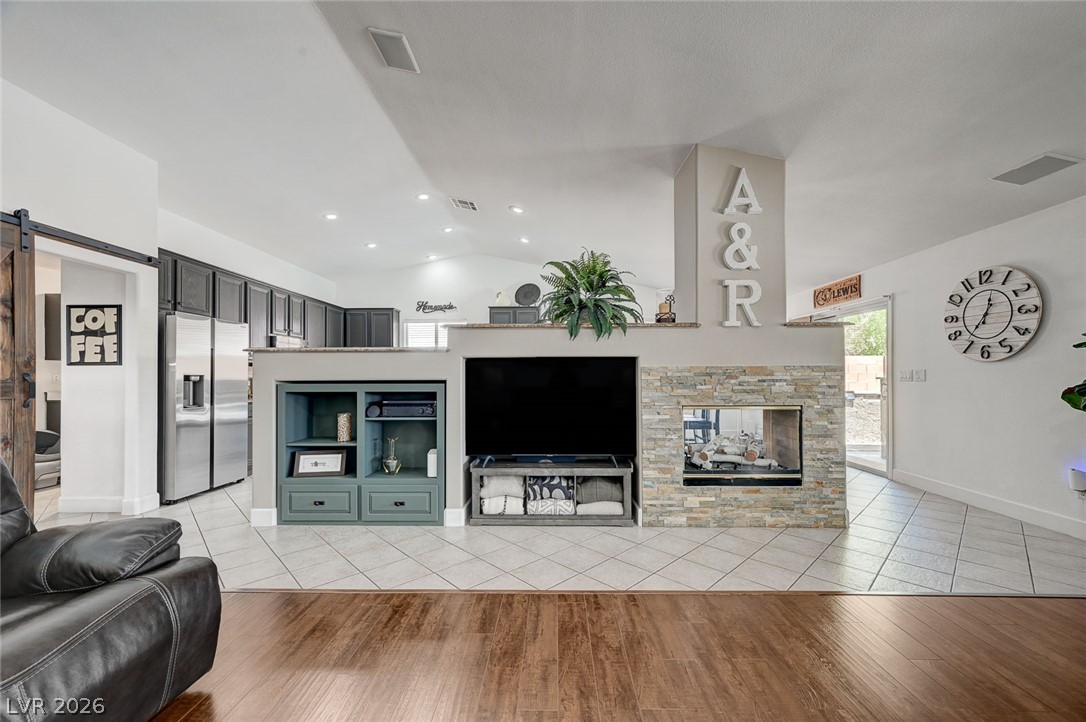 1072 Reed Point Court Henderson, NV 89002 - Photo 60 of 60 A striking stone fireplace divides the spacious living area from the functional kitchen, creating an open yet defined floorplan.