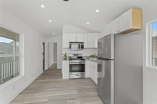 a kitchen with stainless steel appliances a refrigerator and a stove top oven