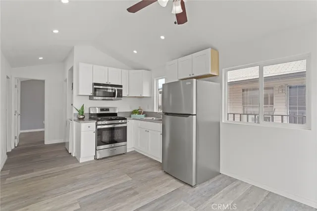 a kitchen with kitchen island white cabinets and stainless steel appliances