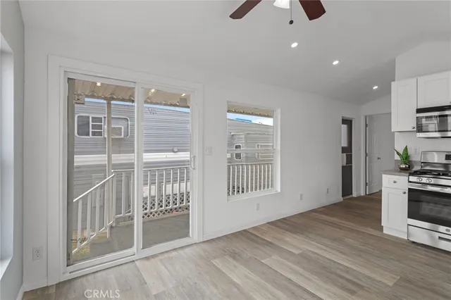 a view of an empty room with a kitchen and a window